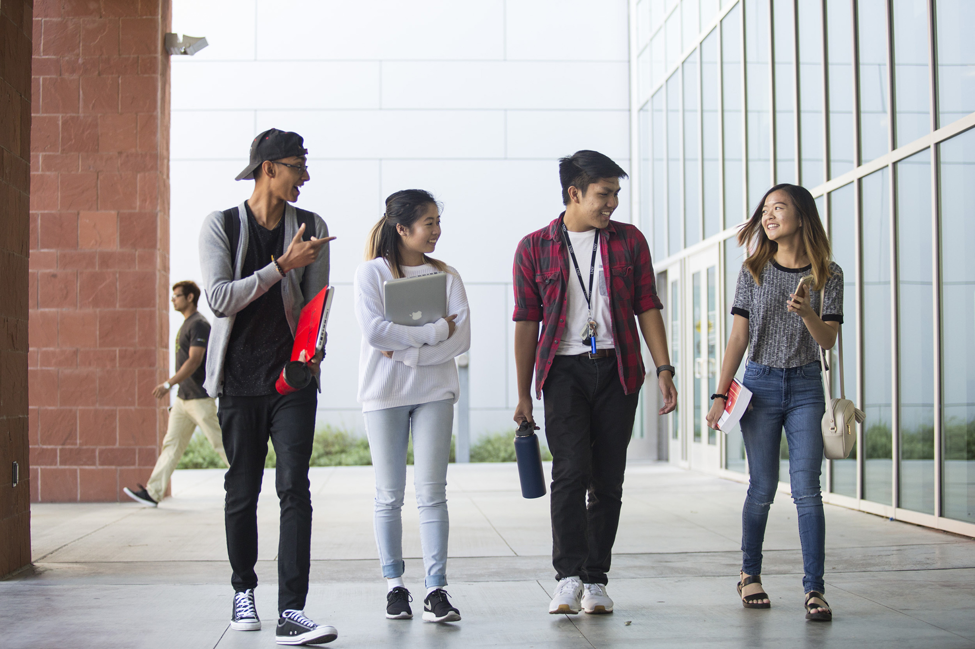 Four students walking and talking together 