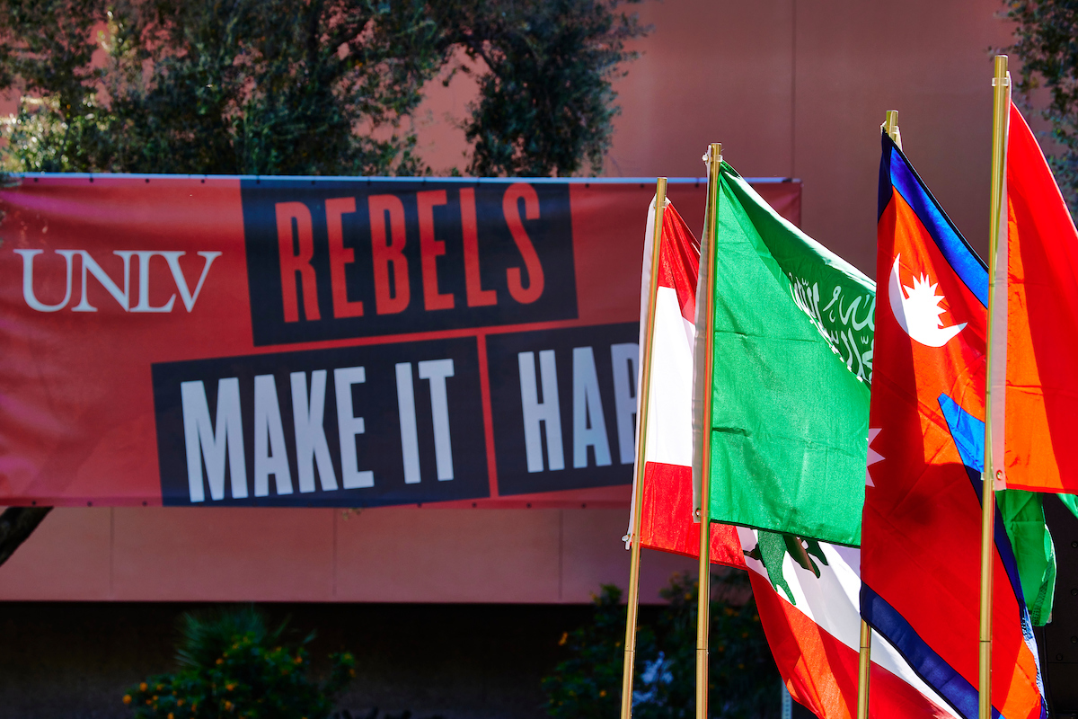 UNLV Rebels Make it Happen banner in front of several international flags