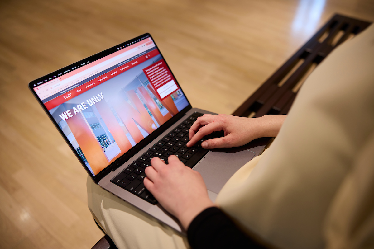 close up of student using a laptop with the screen showing the unlv webpage