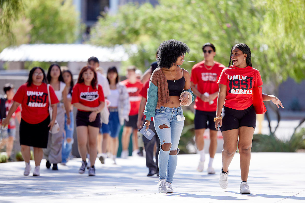 group of students wearing unlv shirts walking towards the camera
