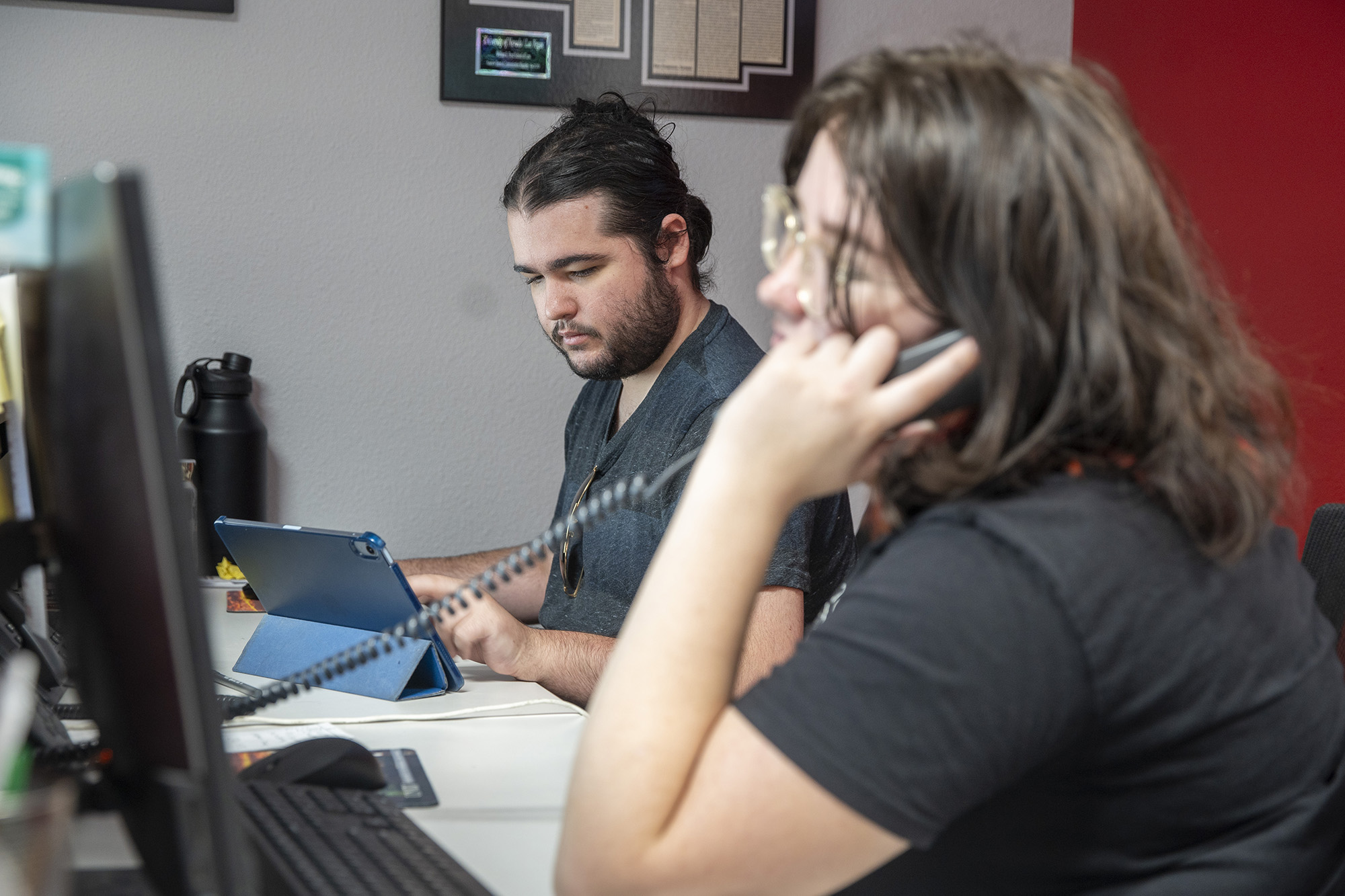 Person sitting at a two-screen computer workstation.