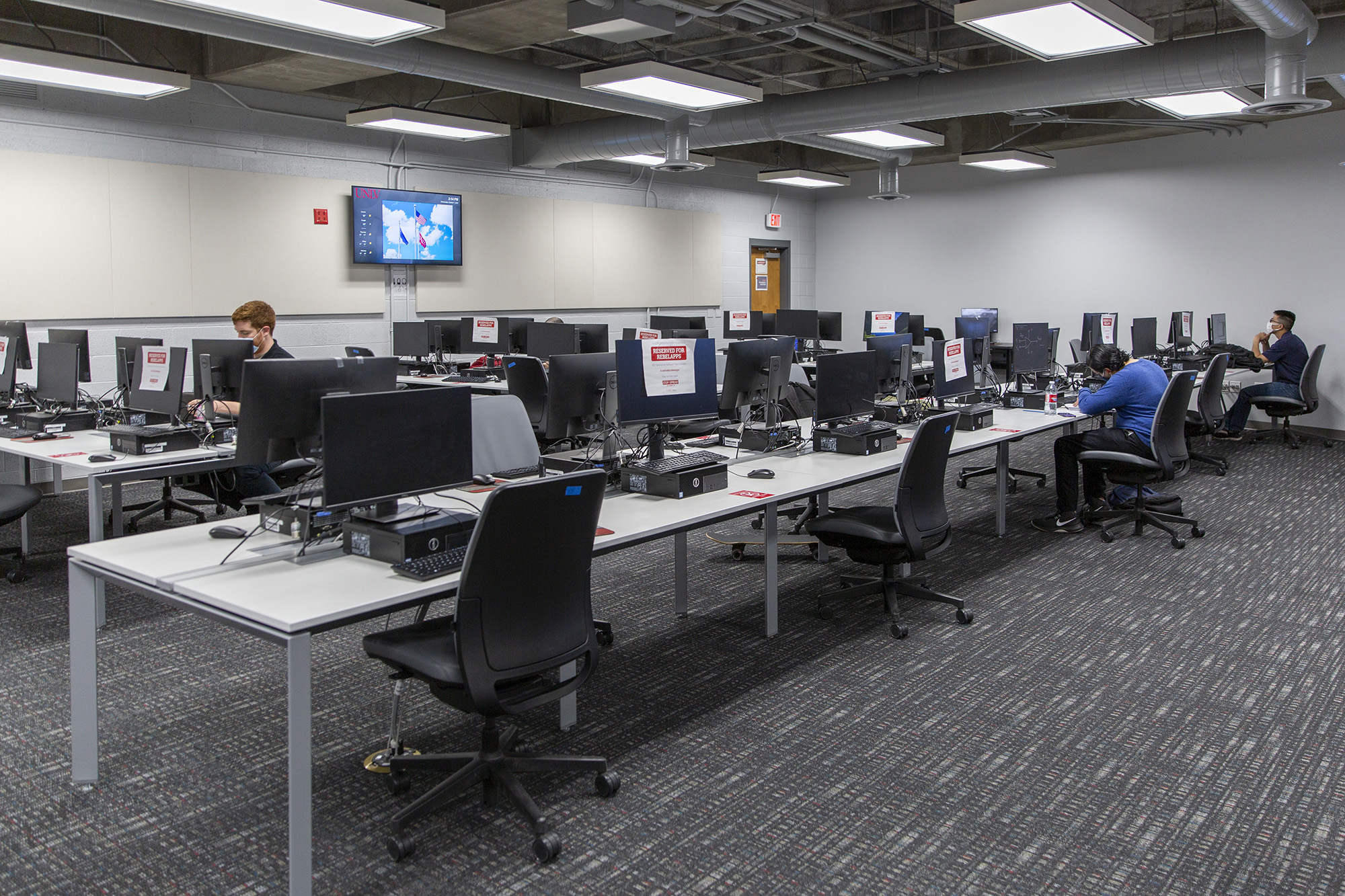 A socially distanced computer lab with a smattering of students.