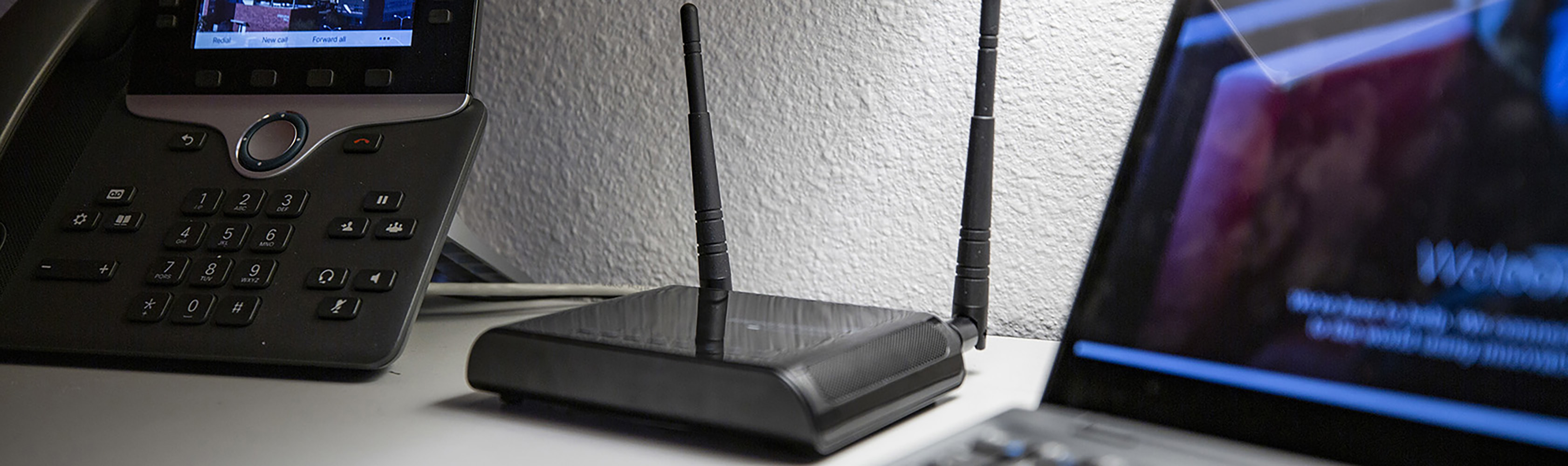 A wireless access point posed  between a VoIP phone and laptop computer.