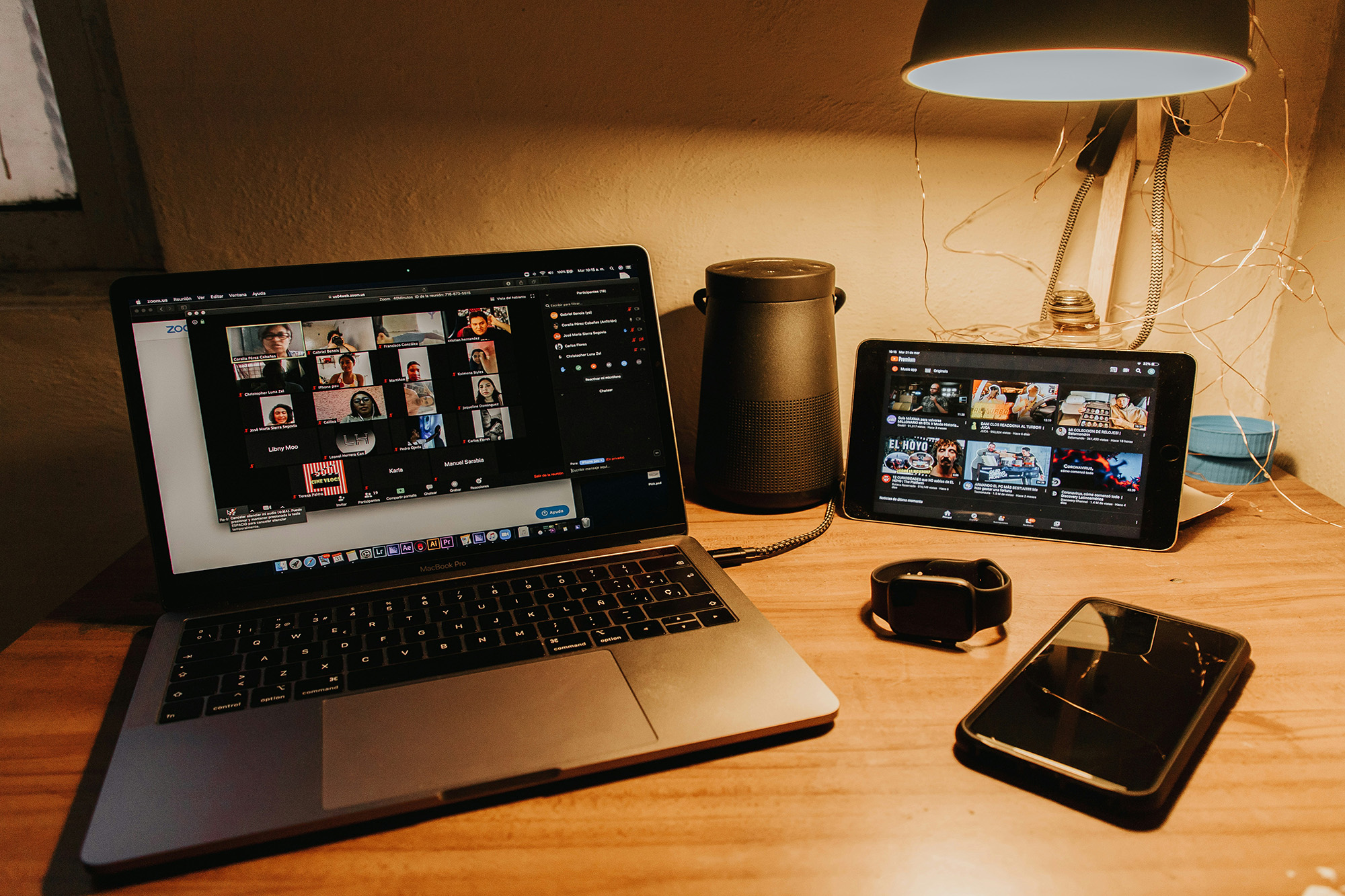 Black and silver laptop computer with open video conference on brown wooden table.