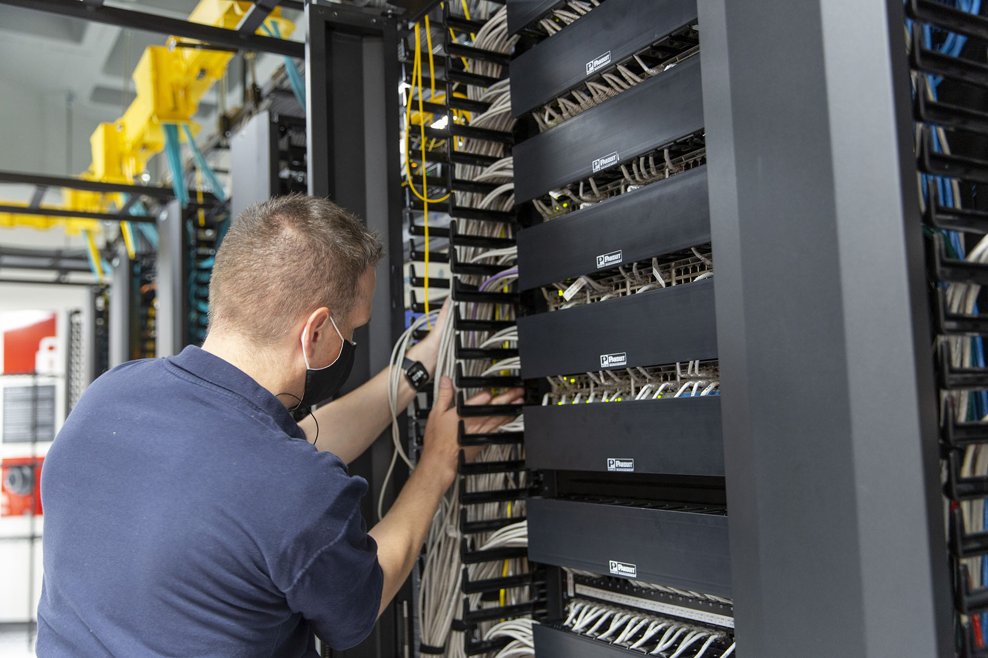 A staff member organizing network cabling.