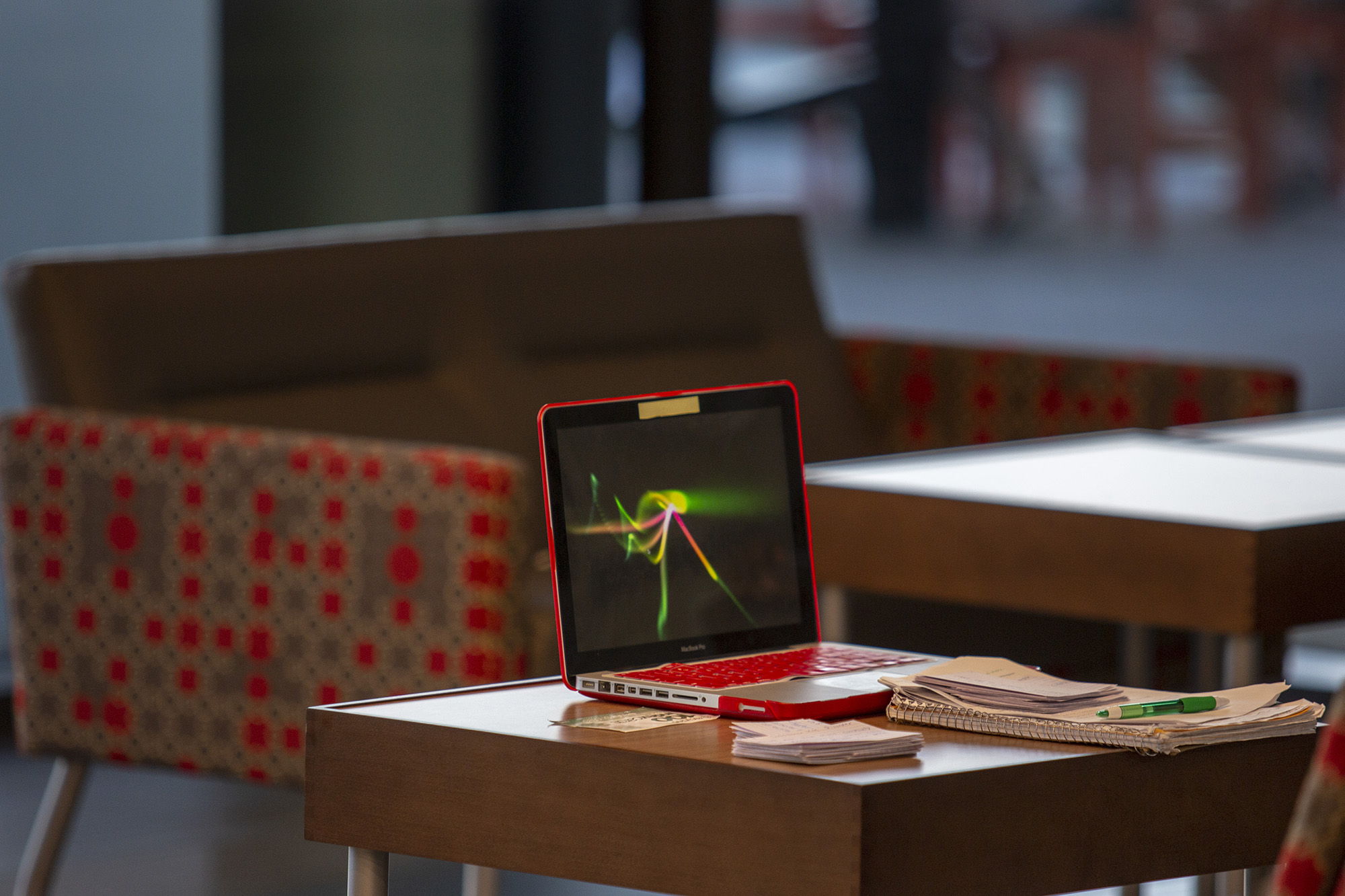 A laptop sits on a desk displaying a screensaver.