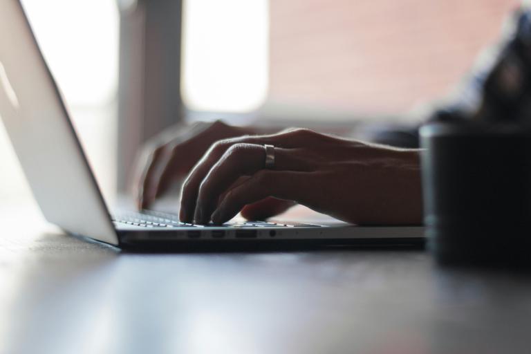 Close shot of hands typing on a laptop.