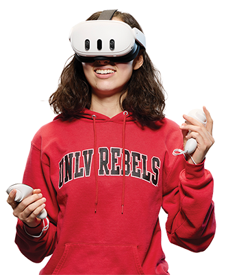 Person wearing a VR headset and holding two controllers while wearing a red UNLV Rebels hoodie.