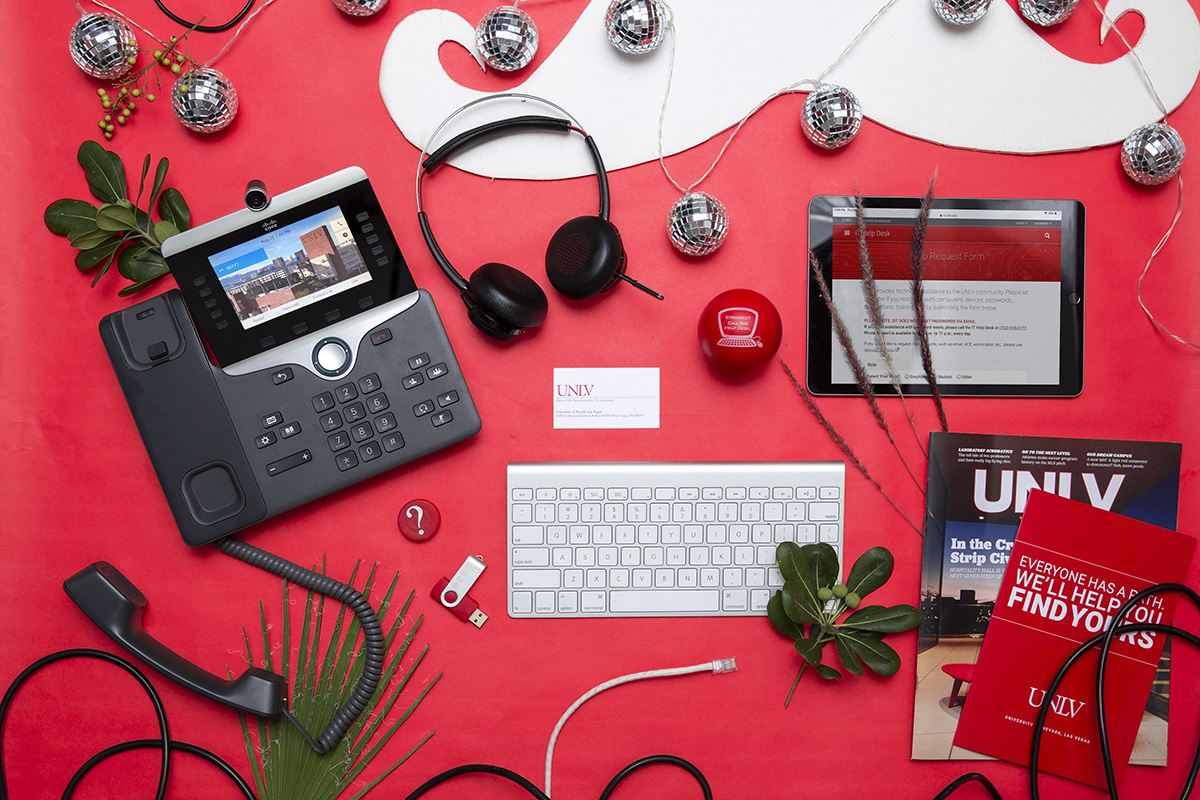 A VoIP phone, headphones, keyboard, tablet, etc. on a red background.