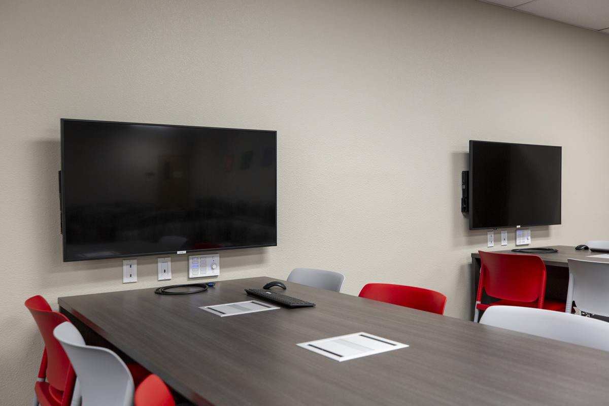 A group table with a large, wall-mounted monitor.