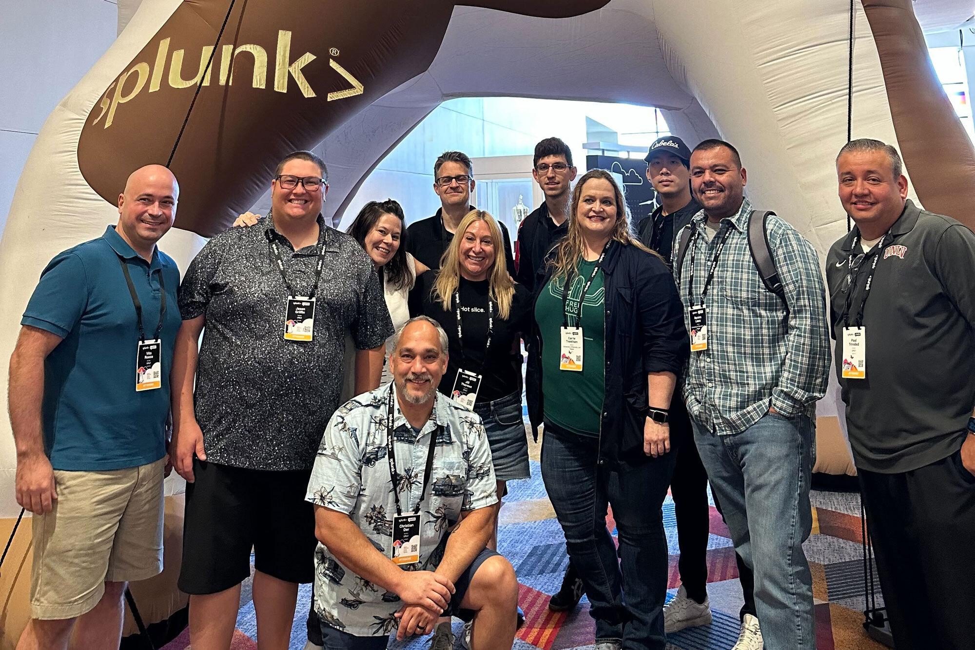 Group of people standing in front of Splunk sign