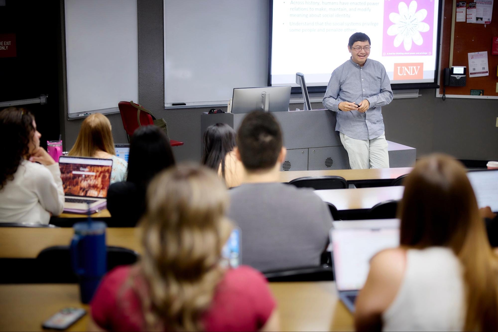 Person standing in front of classroom looking at students sitting at desks