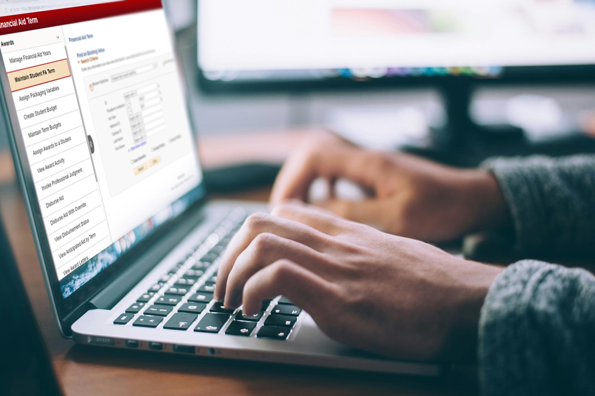 Person typing on laptop keyboard with UNLV WorkCenters financial aid dashboard on the screen.