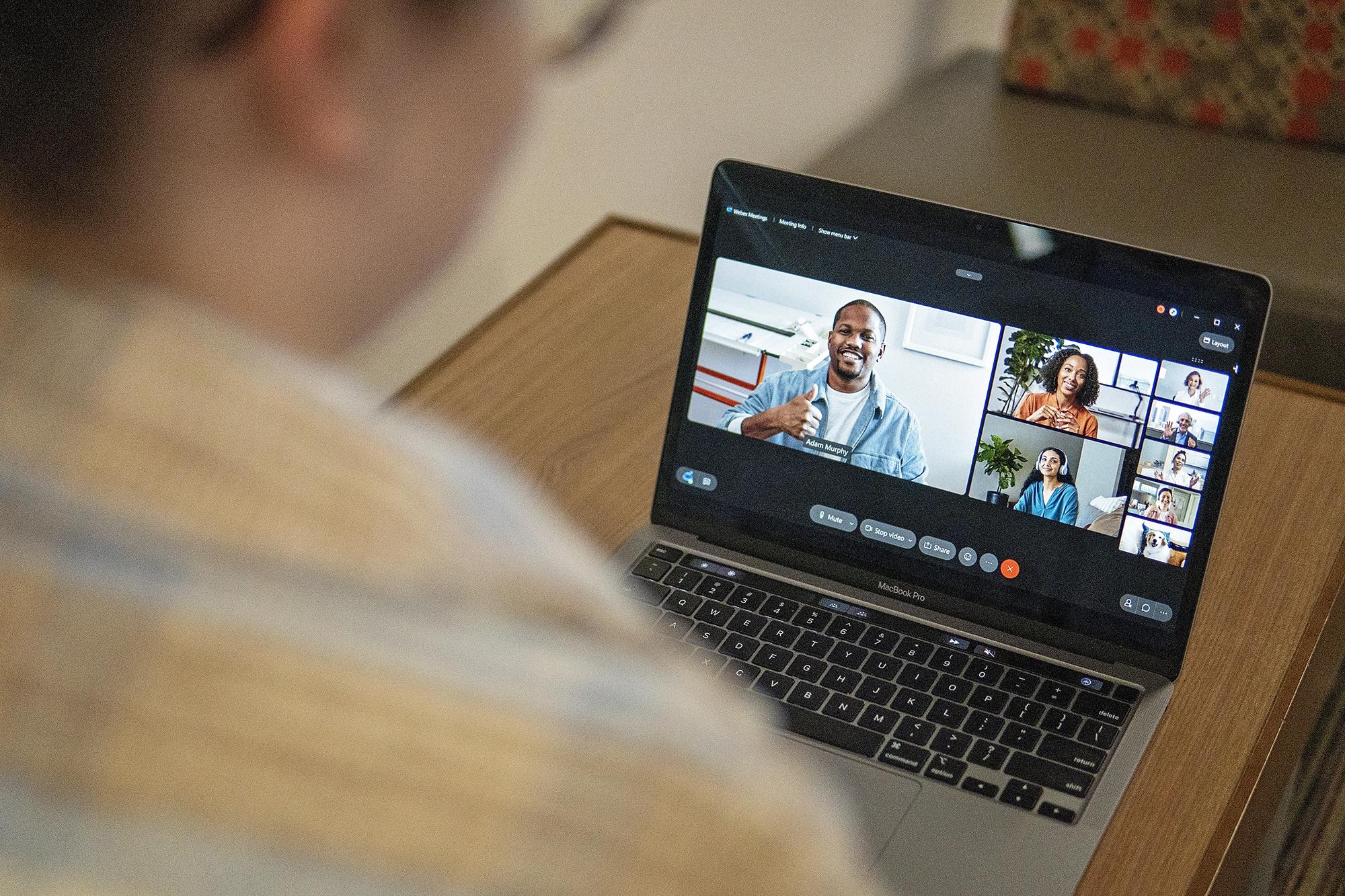A person looking at two people on a laptop computer screen