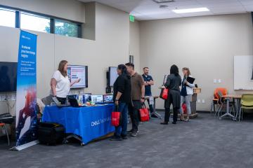 Group of people looking at technology booths 