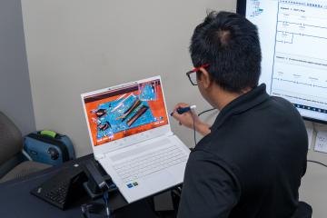 Rakitha Perera looking at 3D laptop and using interactive pen