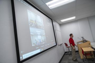 OIT staff member presenting RebelFlex software on projector screen at InfoComm 2022.
