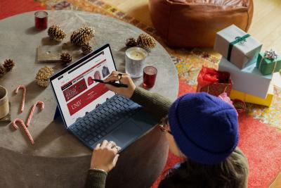 Person sitting at table looking at a shopping website on laptop computer