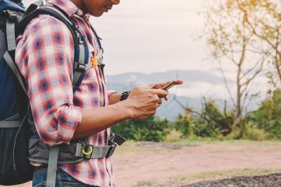 Man on hike looking at phone. 