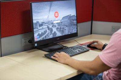Person’s arms typing on keyboard behind a desktop computer in a computer lab.