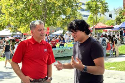 Kivanc Oner talking with student at Involvement Fair. 