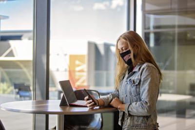 Person standing near table holding a smartphone