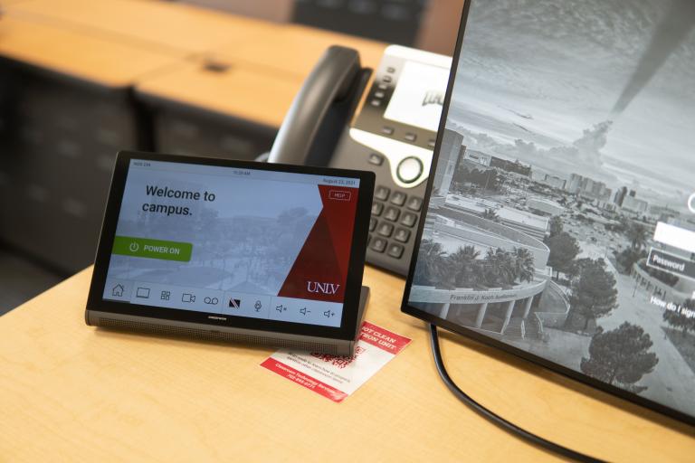 Desk with computer screen, touchpad, and desk phone