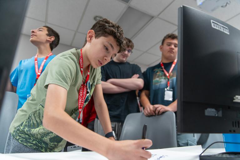 High School students partaking in group activity around computers