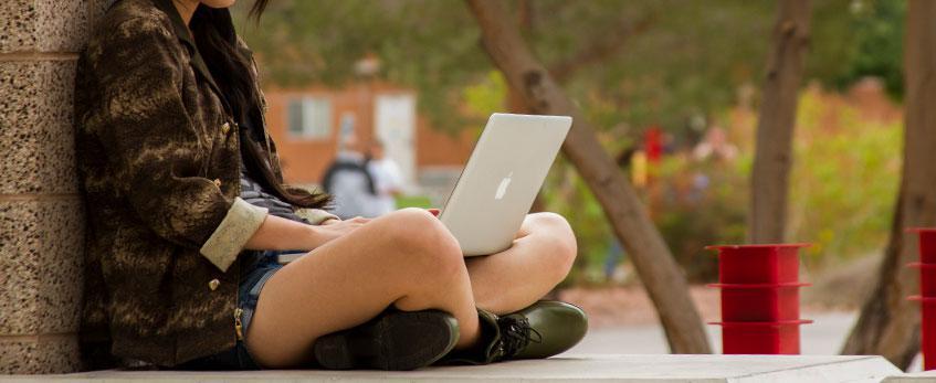 A female student types on her laptop.